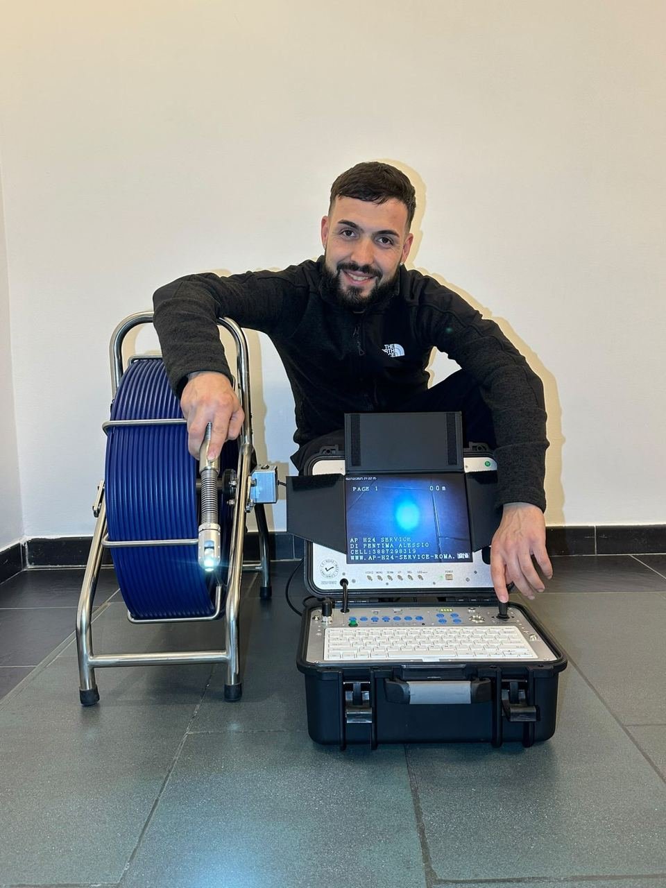Alessio Pentima of AP H24 Service next to the camera reel and the monitor used for drain inspections