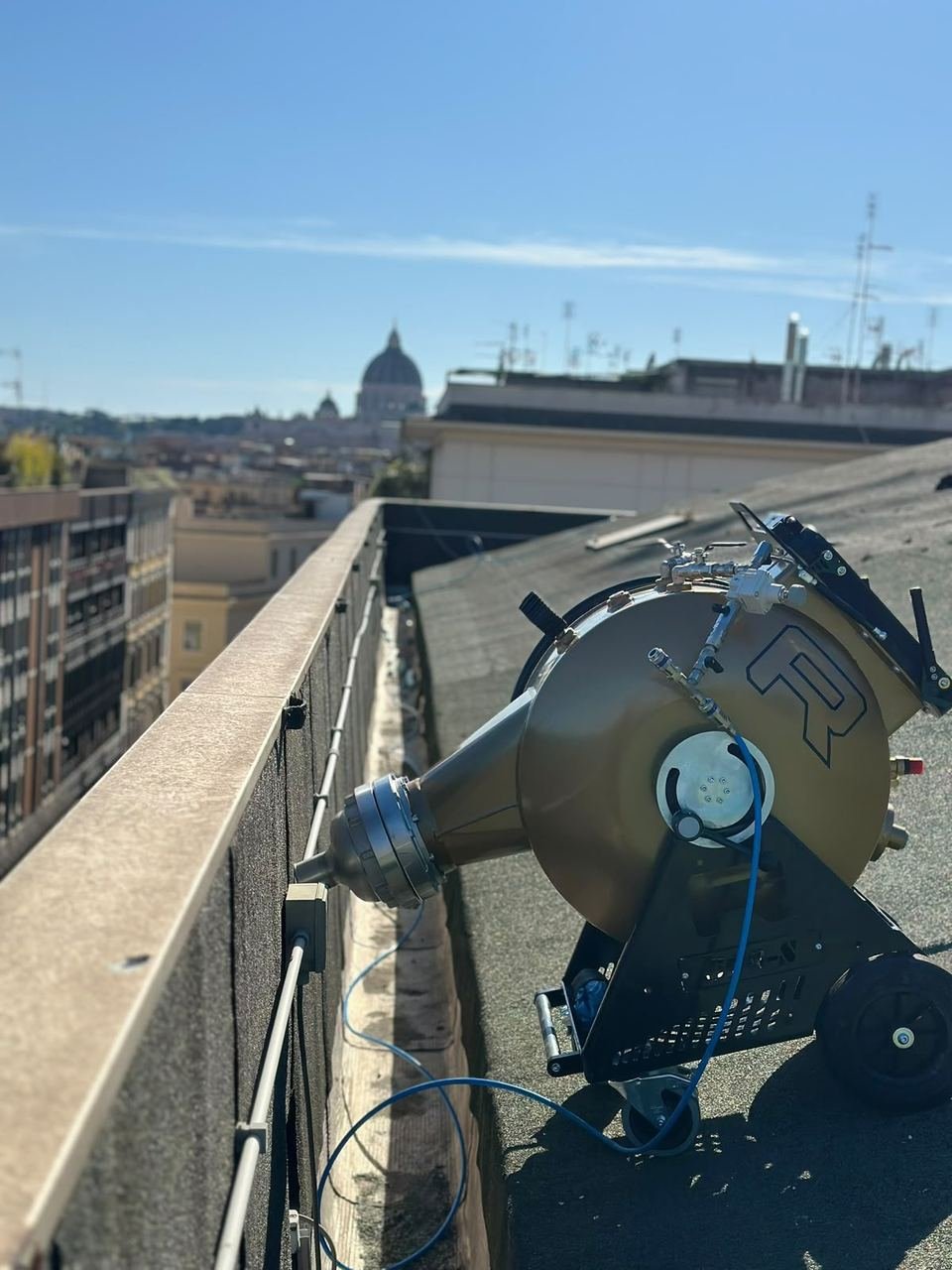 Macchina da lavoro su un tetto di Roma, con la cupola di San Pietro sullo sfondo