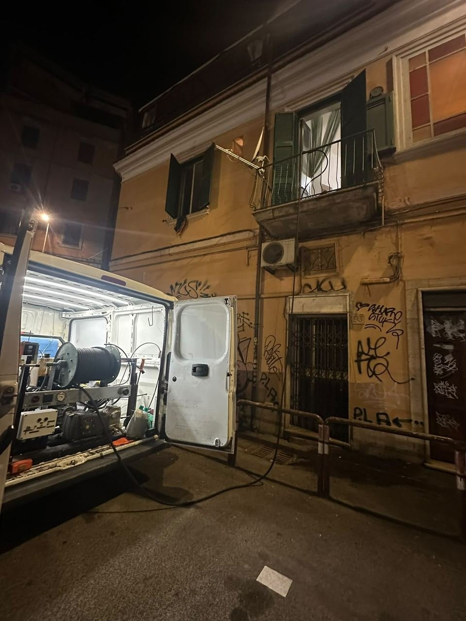 Furgone aperto con l'attrezzatura, di notte, davanti a un palazzo di Roma